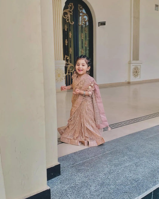 Child in a traditional outfit standing in a decorated interior setting